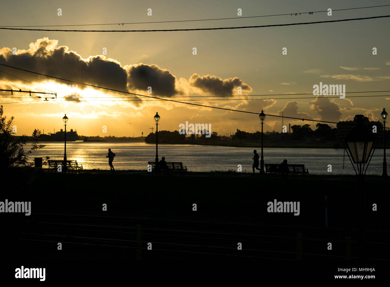 Joggers at sunrise by the Mississippi River at New Orleans Stock Photo ...