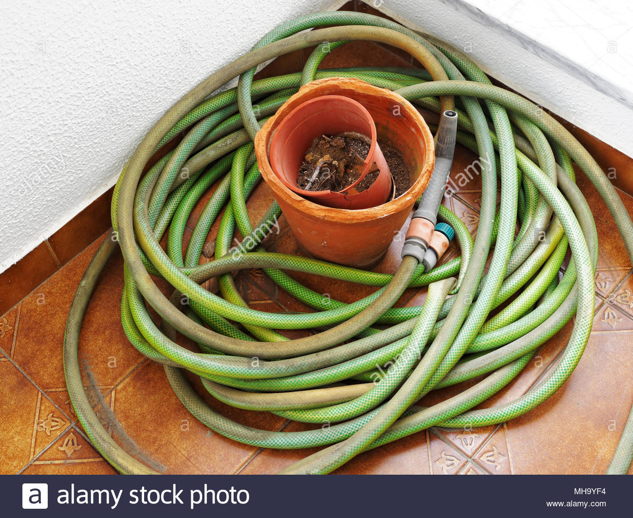 Old And Dirty Coiled Garden Hose With Worn Fittings And Broken