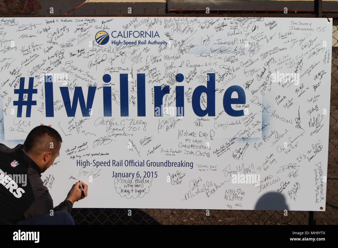 Signing the 'I Will Ride' poster at the California High Speed Rail Groundbreaking Ceremony in Fresno Stock Photo