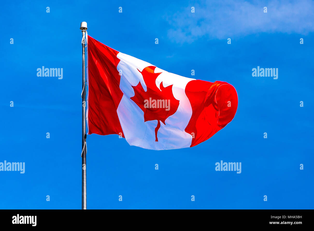 Flag of Canada flying against a blue sky. North America Stock Photo