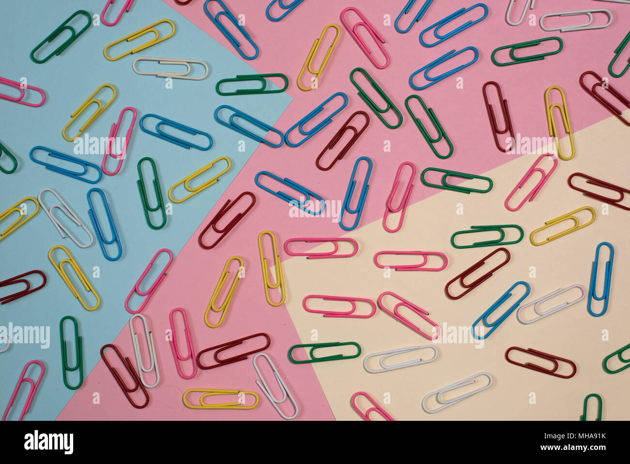 colourful paper clips on colourful pastel colour background. diversity