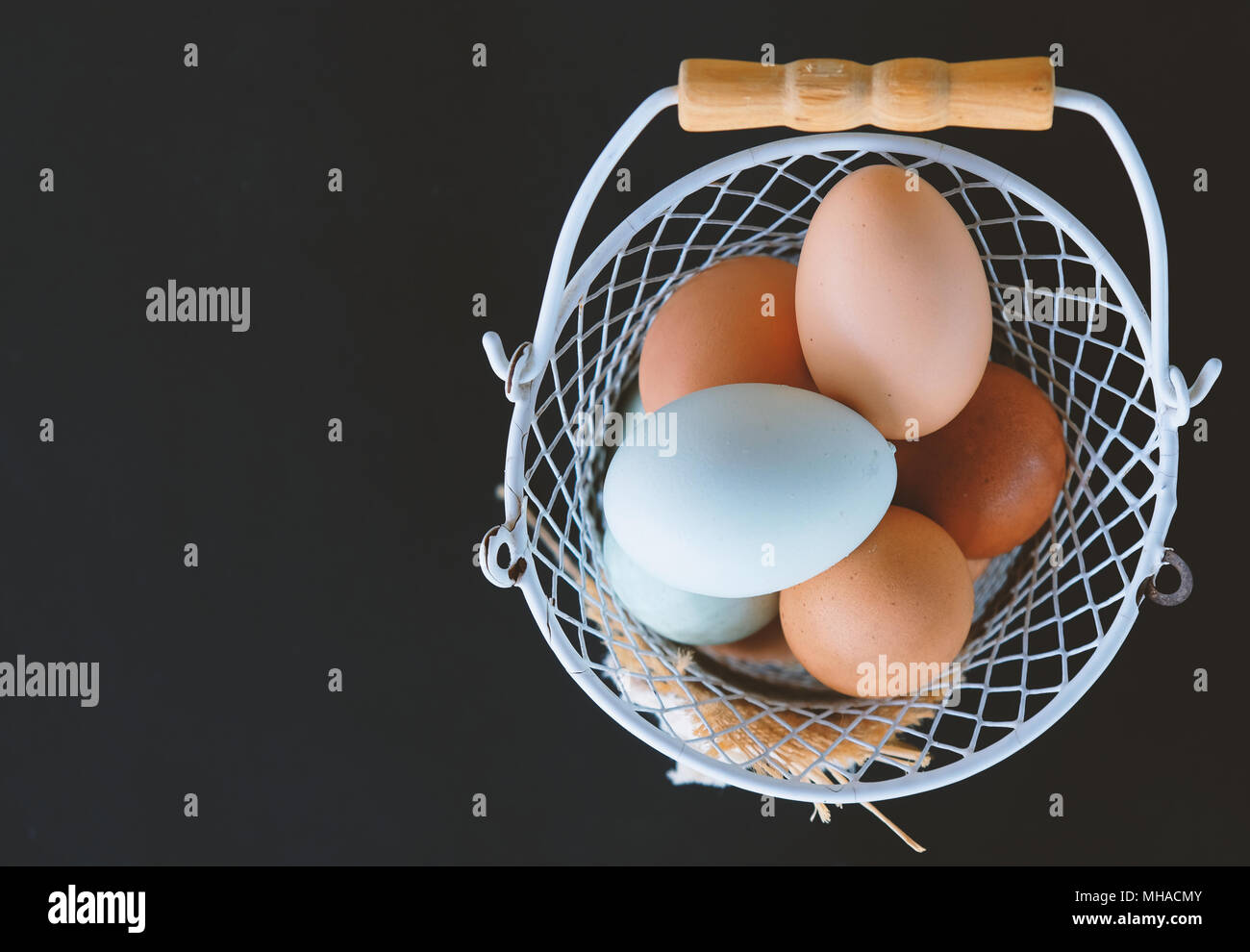 View from above of farm fresh cage free chicken eggs.  Agriculture harvest for breakfast in basket against a black background Stock Photo