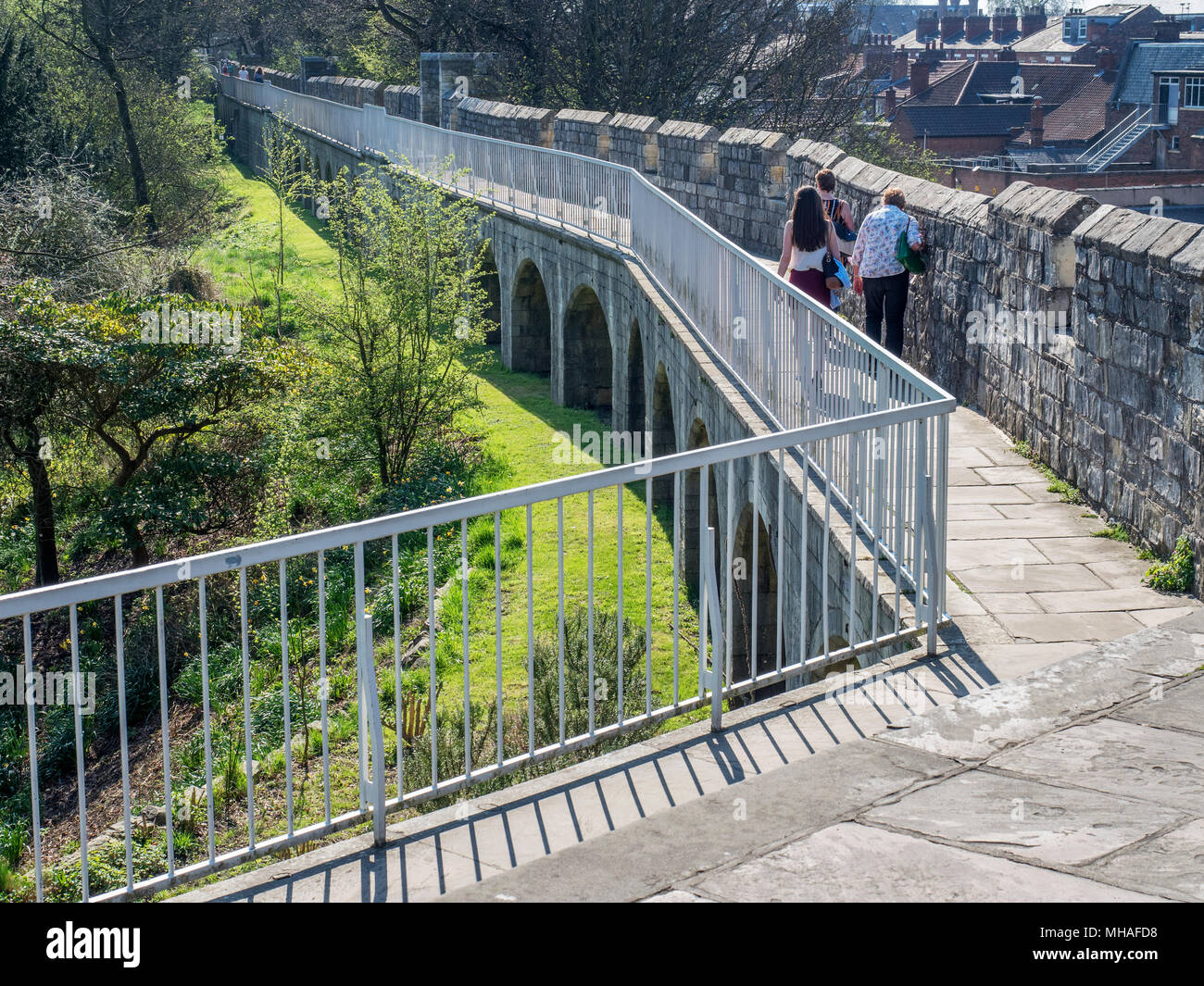 Walking along the city wall from Robin Hoods Tower toward Bootham Bar York Yorkshire England Stock Photo