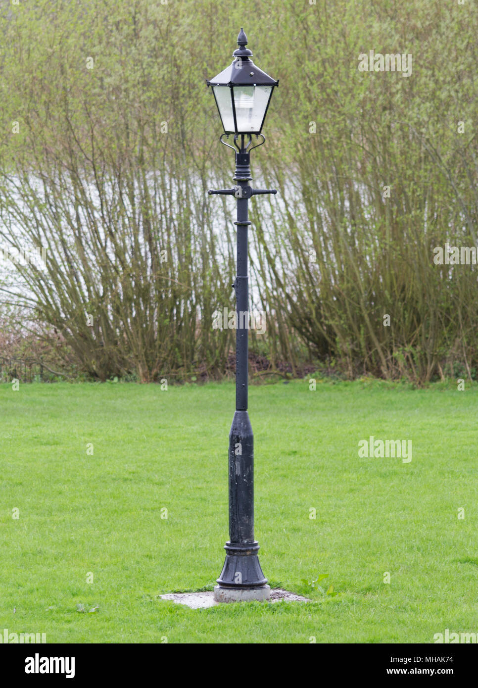 An antique lamp post in the grass nearby water Stock Photo - Alamy