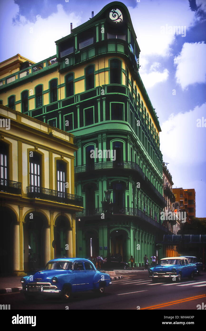 Vintage Cars on Havana street in front of colorful buildings, Cuba Stock Photo