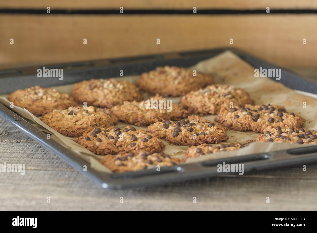 Freshly baked homemade oatmeal cookies in assortment (drops of brown and white chocolate and cookies sprinkled with walnuts). View at an angle. Close- Stock Photo