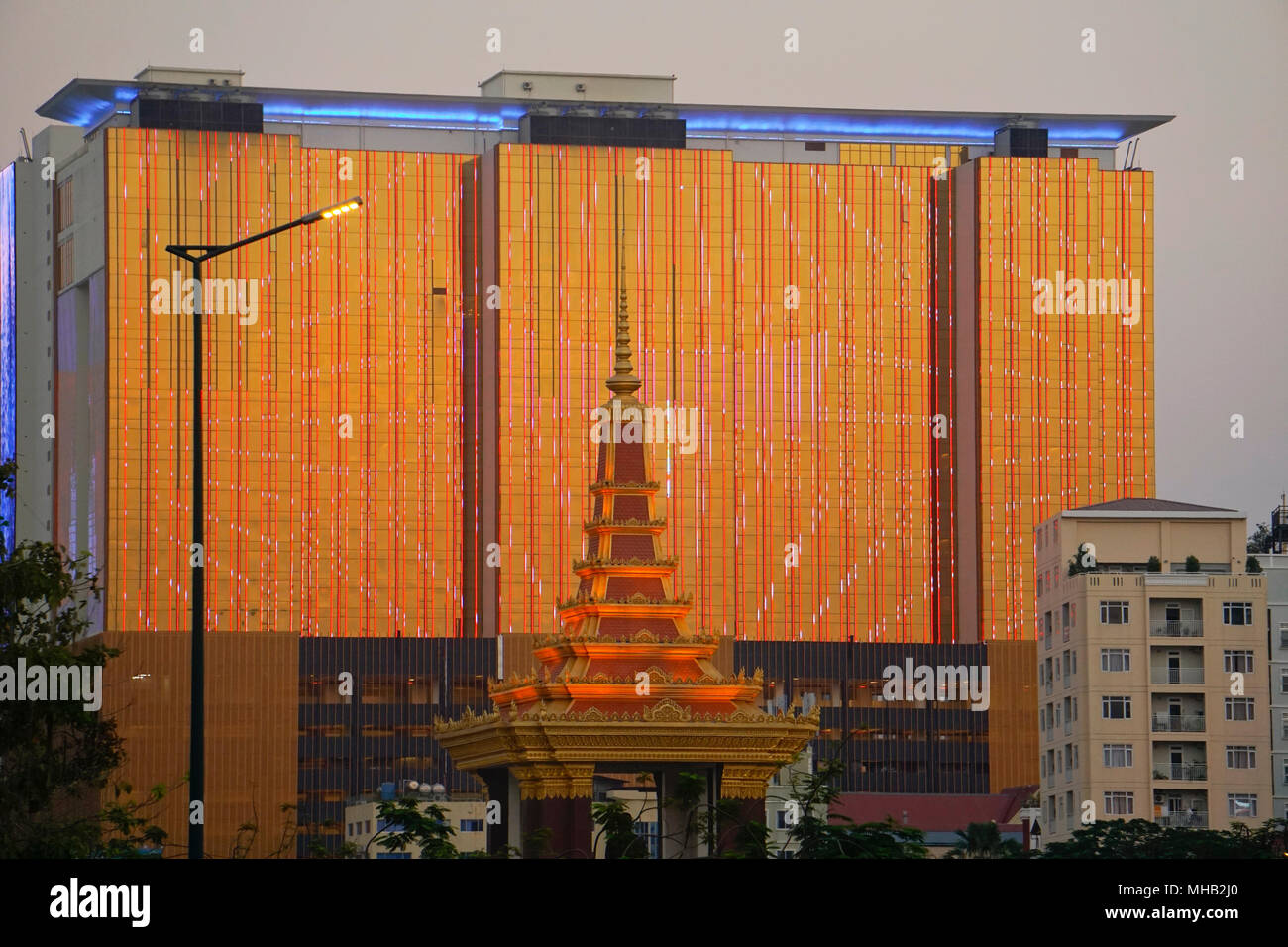 Monument to King Norodom Sihanouk in  Independence Park and the Naga 2 Hotel and Casino, Phnom Penh city, Cambodia; Stock Photo