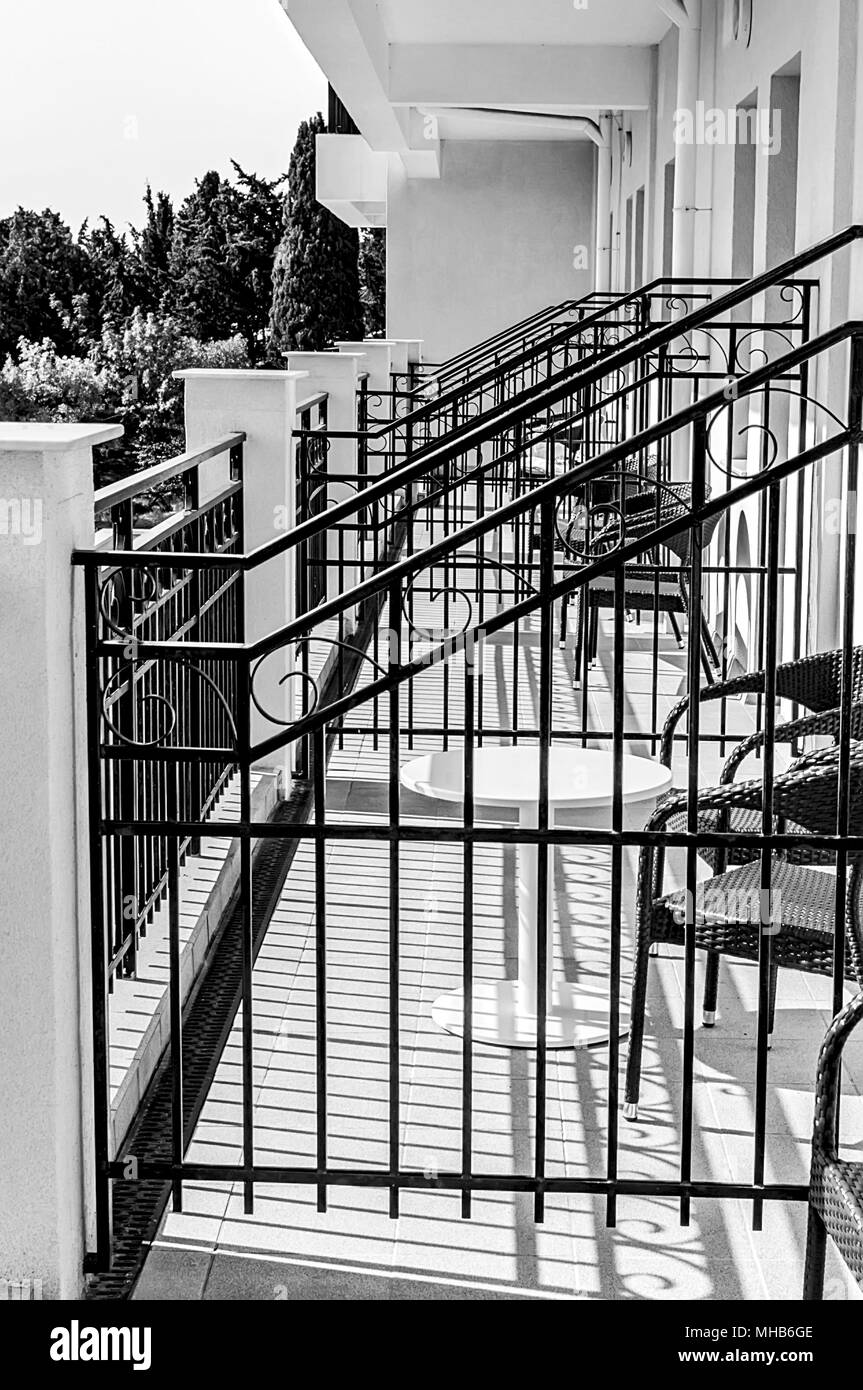 Balconies with tables and chairs at best sunny weather in black and white Stock Photo