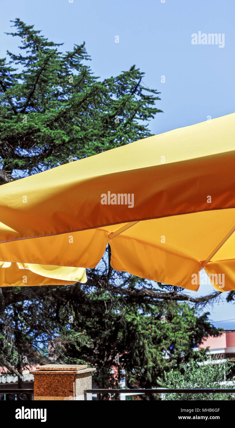 Yellow awning sun umbrella at happy bright weather Stock Photo