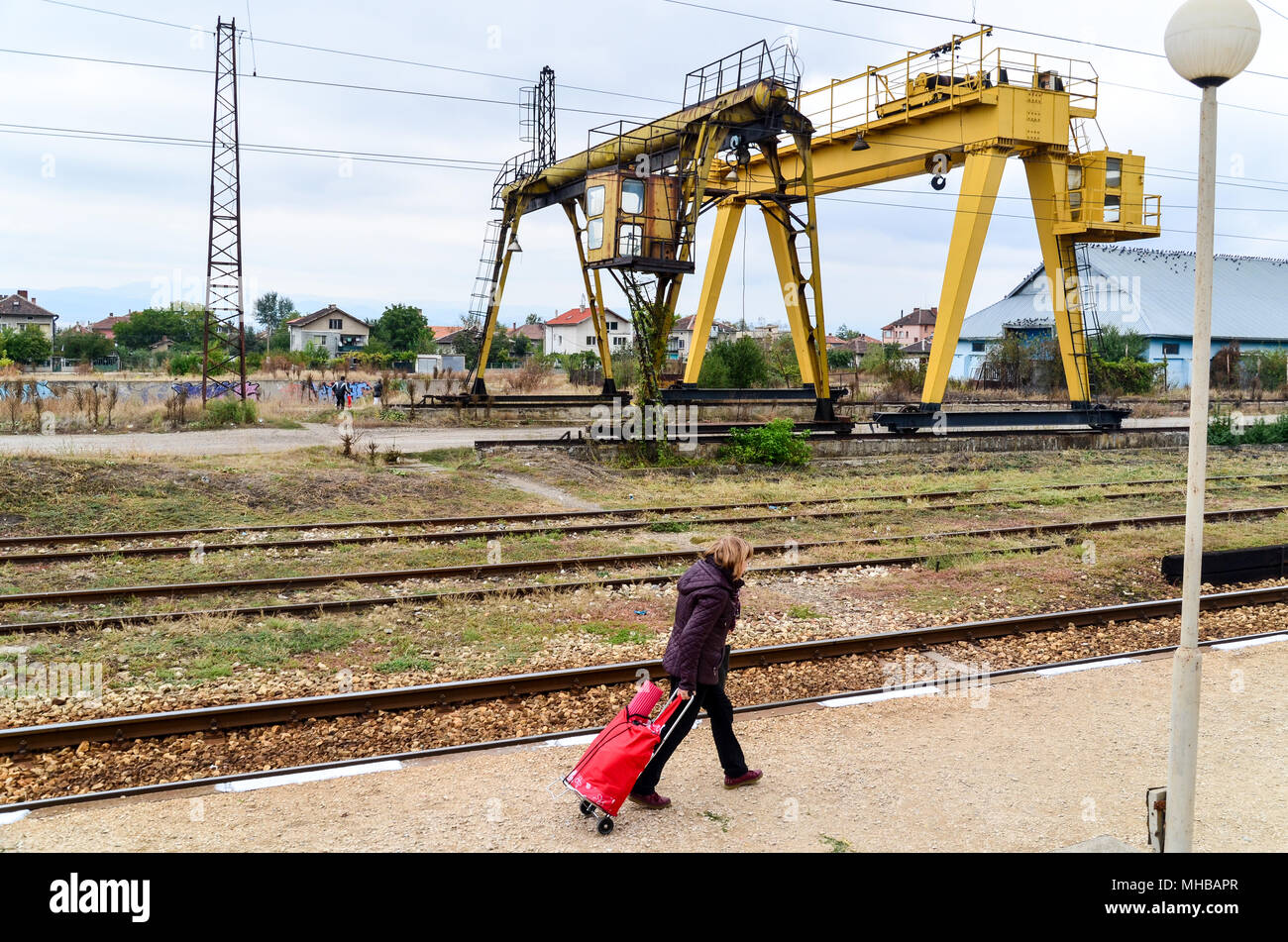 Bulgarian woman and a bag in a rural train station between Sofia and Plovdiv, Bulgarian State Railways (BDZ) in Sofia, Bulgaria Stock Photo