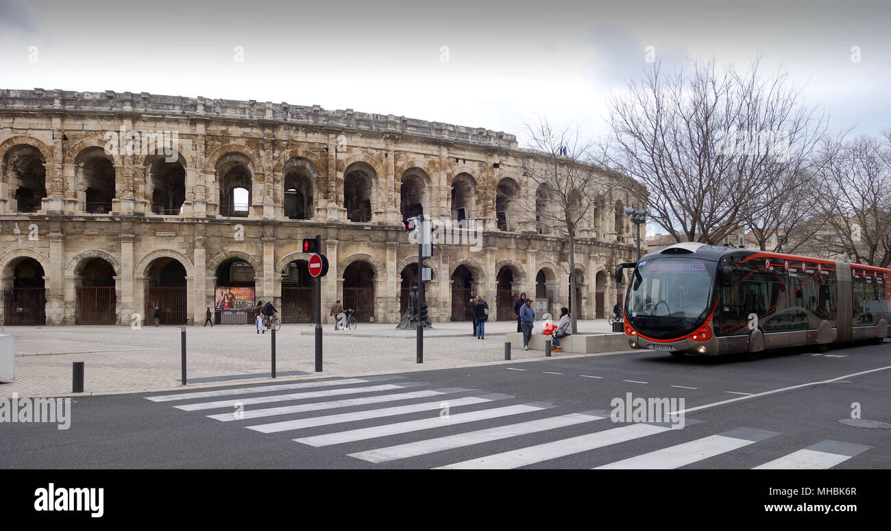 Old and new! Modern bendy bus passing the Roman Arena in Nimes France 2018 Stock Photo