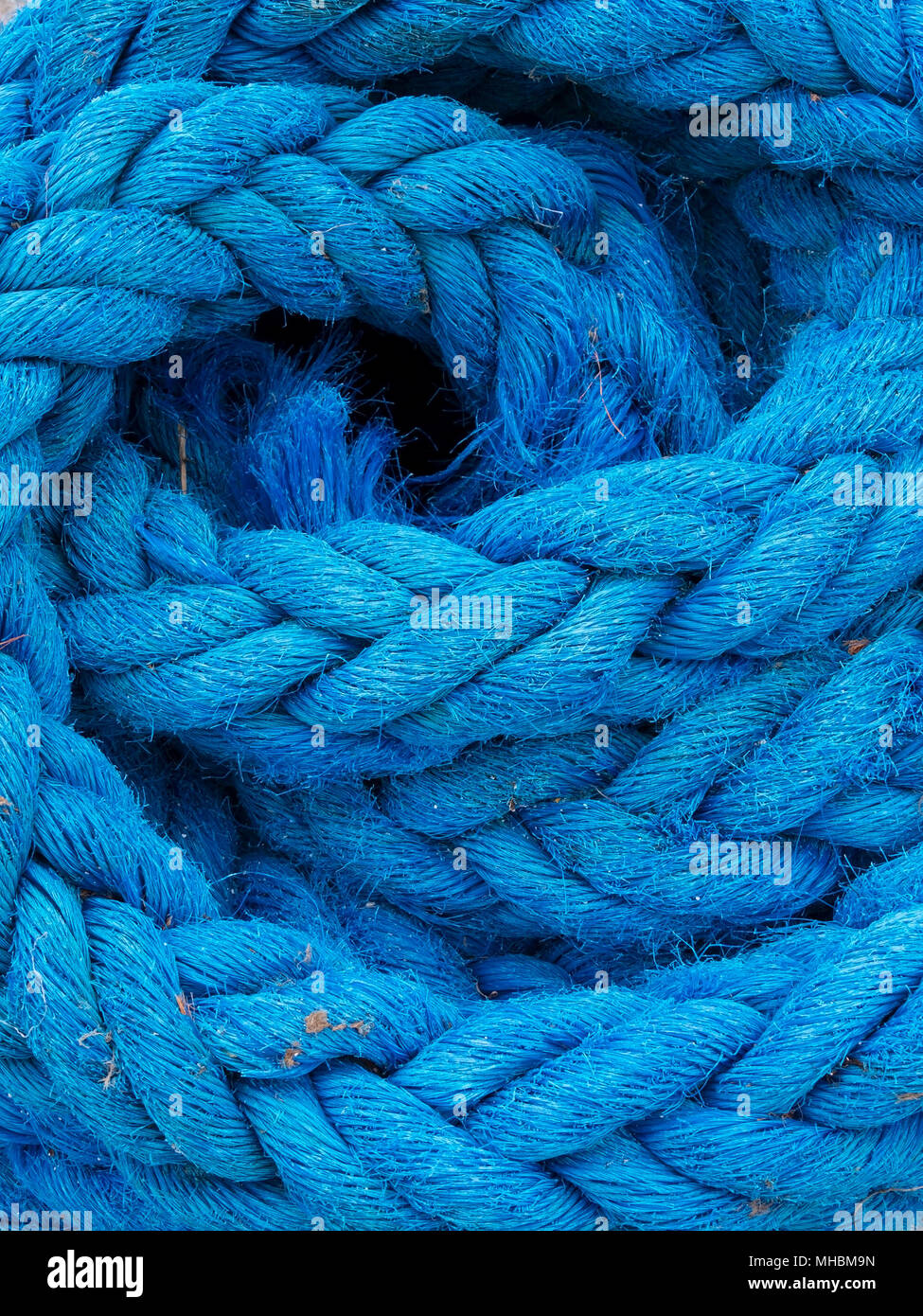 Coil of thick blue discarded nylon rope Stock Photo