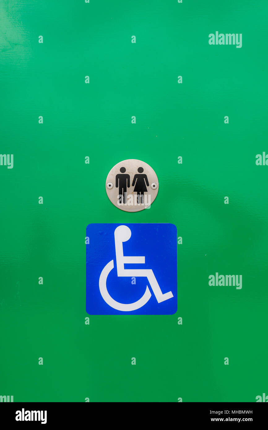 Disabled toilet sign, against a green background Stock Photo