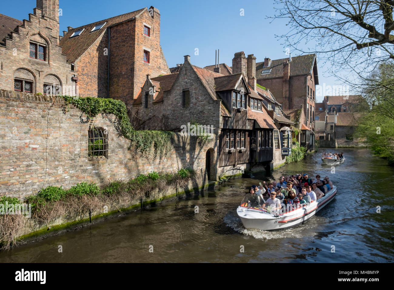 People enjoying a boat trip on one of the Canals of Bruges Stock Photo