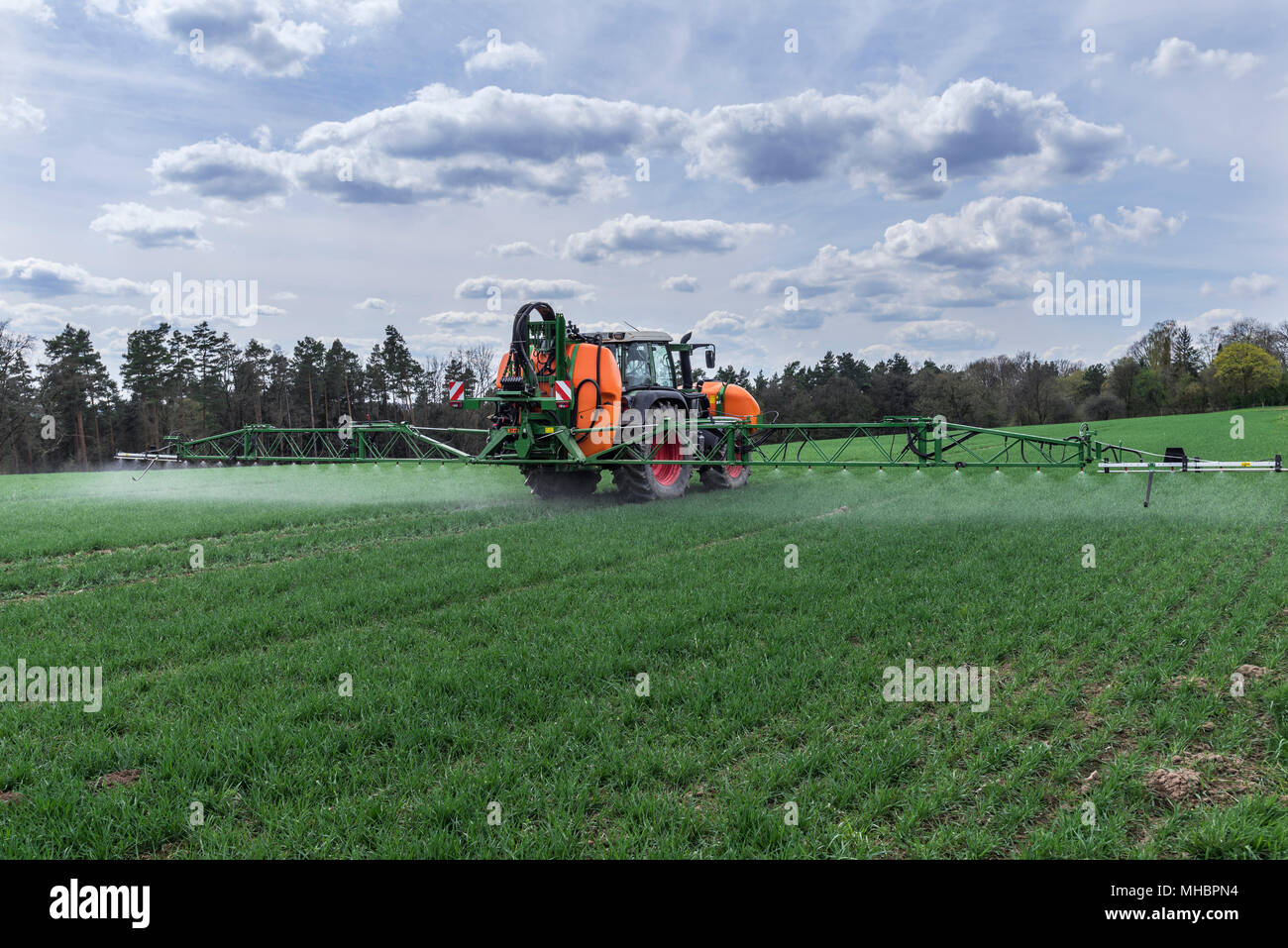 Modern high-tech sprayer in use on a germinating wheat field, Franken, Bavaria, Germany Stock Photo