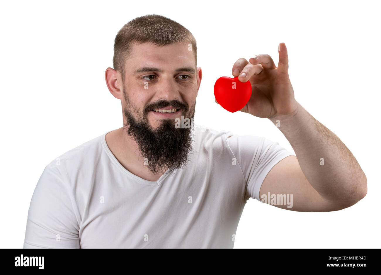 Handsome man in the white t-shirt holding red heart in his hands with ...