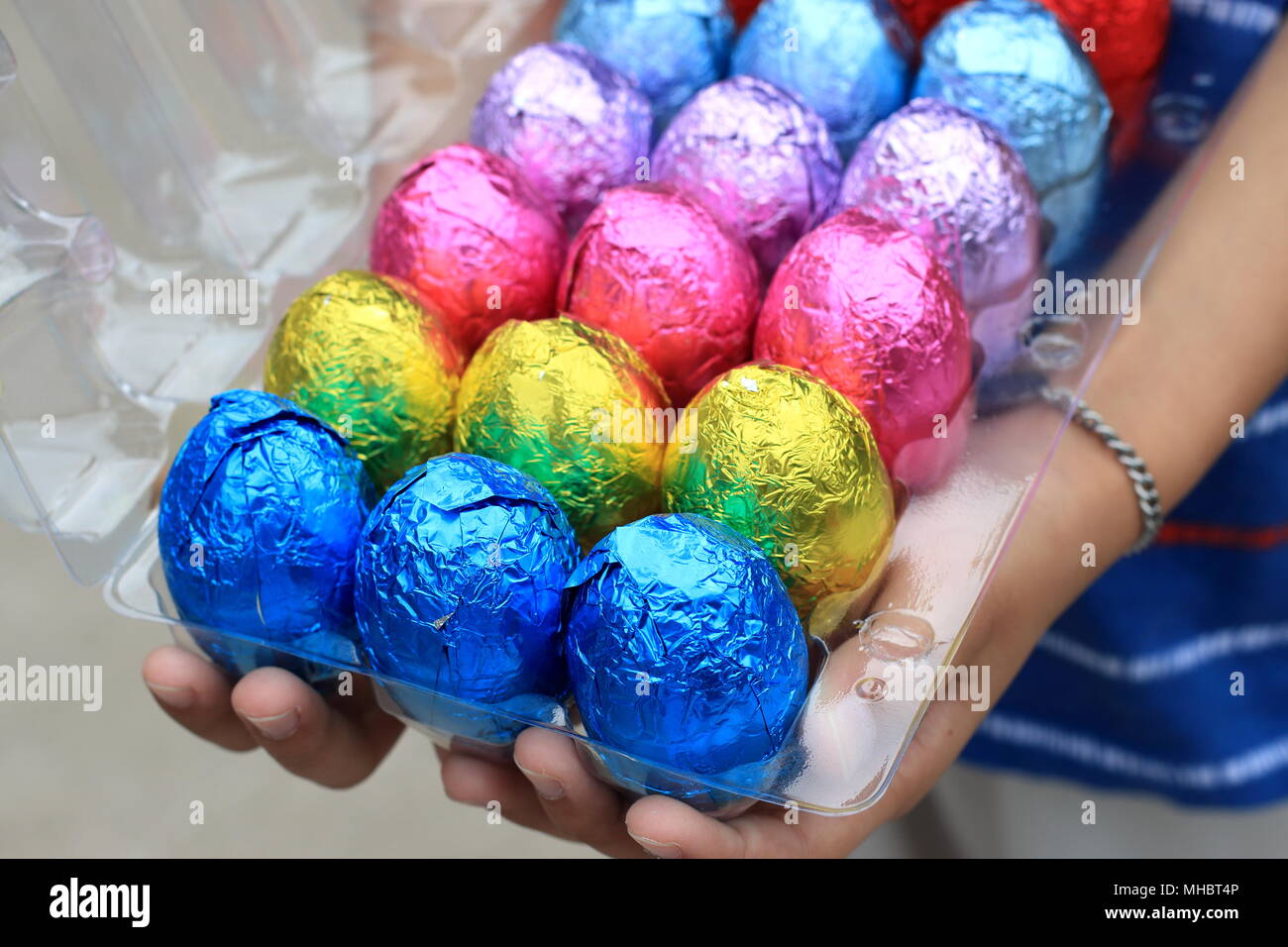 Hand holding Colourful Chocolate Eggs on plastic carton Stock Photo Alamy