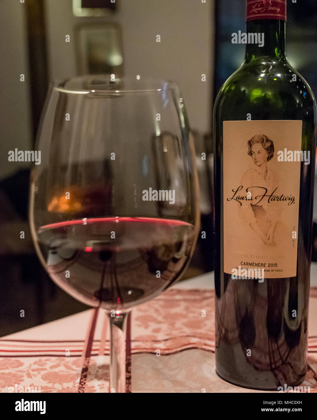 Wine glass and bottle of Laura Hartwig Caminere 2015 red wine, Italian restaurant, Santa Cruz wine region, Colchagua Valley, Chile, South America Stock Photo