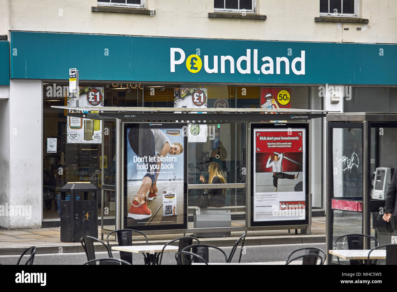 Bus stop shelter in front of a Poundland store on Cheltenham Lower High Street Stock Photo