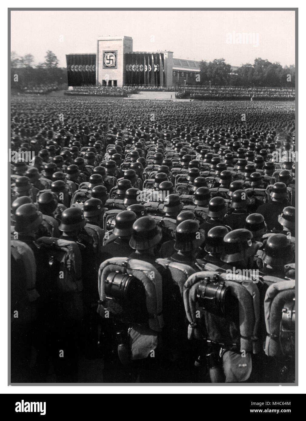 Nazi Waffen SS troops wearing polished helmets in precise serried ranks standing at salute during a German Nazi rally pre-World War II Nuremberg 1930's Stock Photo