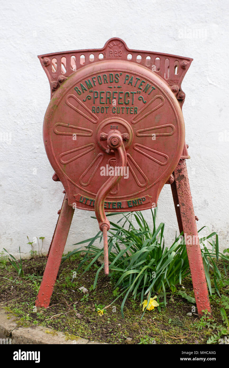 Restored Vintage Bamfords Perfect Root Cutter used as a garden decoration. Antique farm machinery. Stock Photo