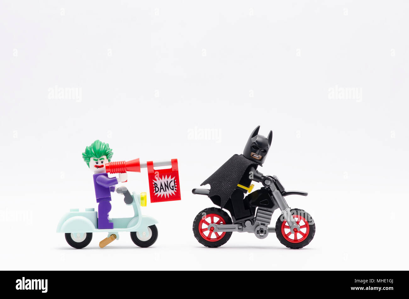 mini figure of joker riding scooter with bang gun chasing batman with dirt  bike. Lego minifigures are manufactured by The Lego Group Stock Photo -  Alamy