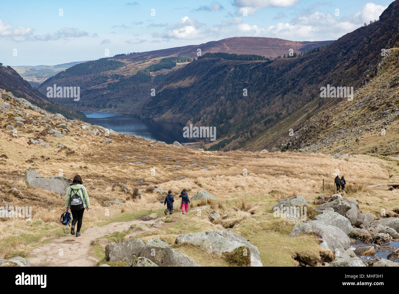 Hikers walking in the picturesque  Glenealo Valley following white route trail in Glendalough Park, County Wicklow, Ireland Stock Photo