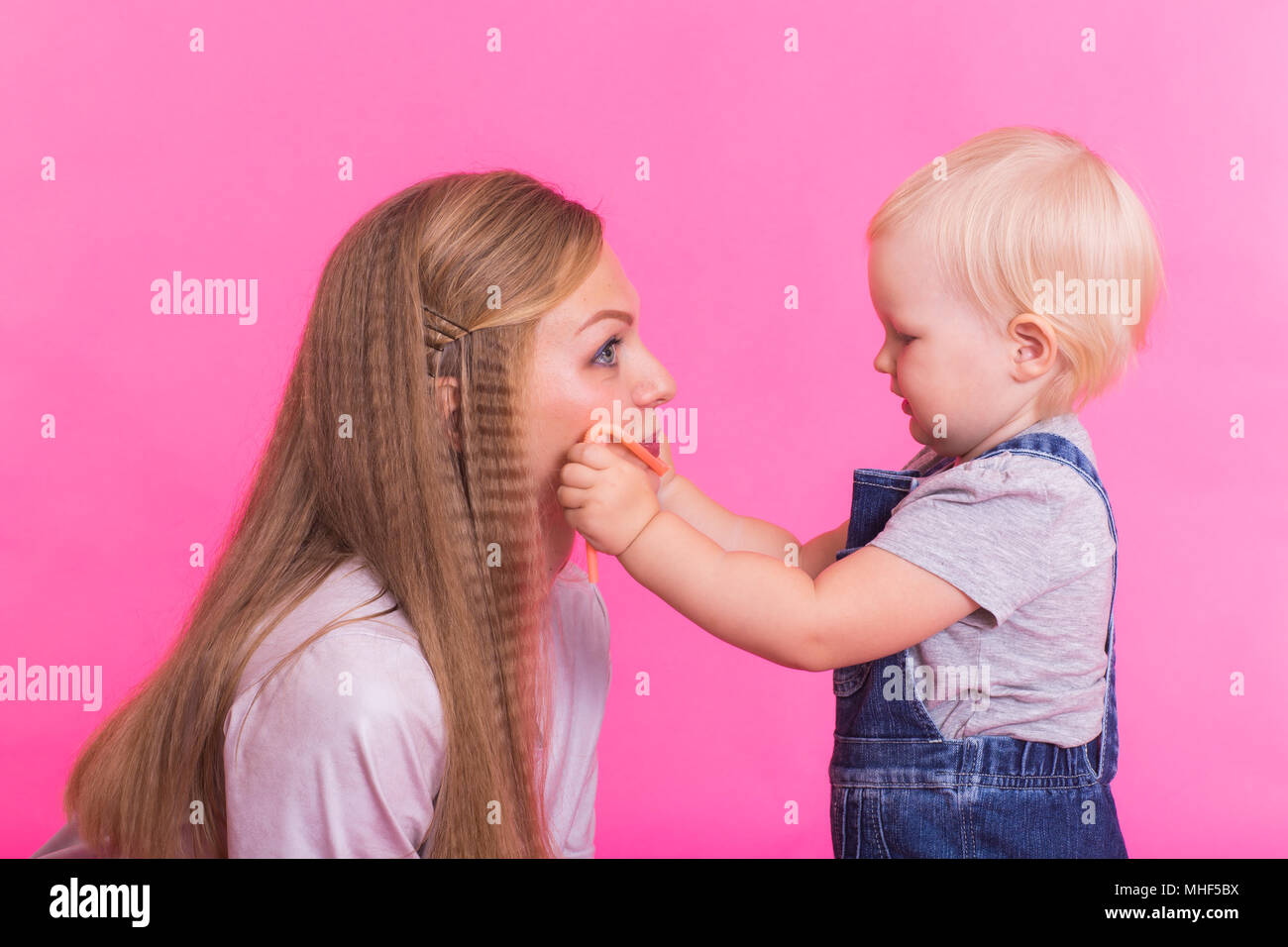 Funny family on pink background. Mother and her daughter girl. Mom and ...