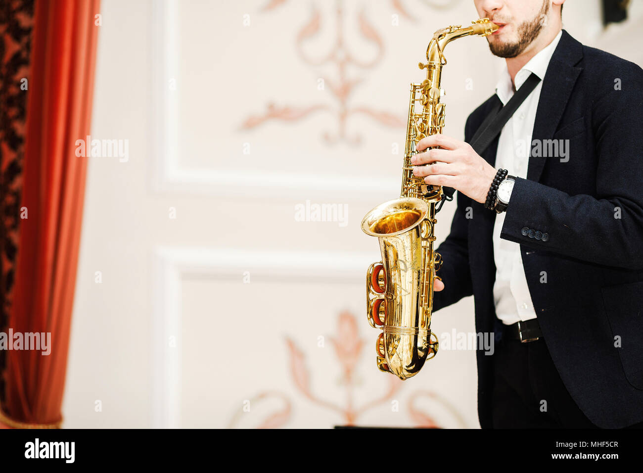 handsome businessman play saxophone isolated on black Stock Photo