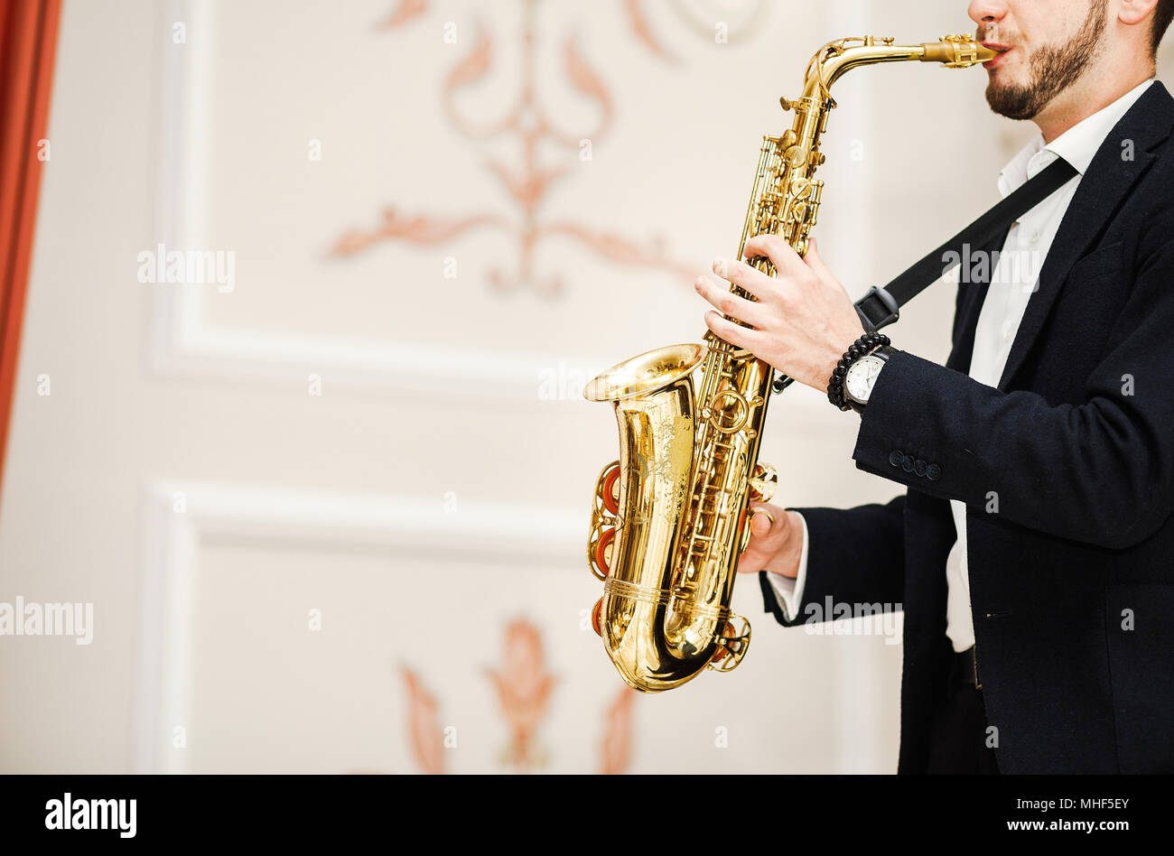 handsome businessman play saxophone isolated on black Stock Photo