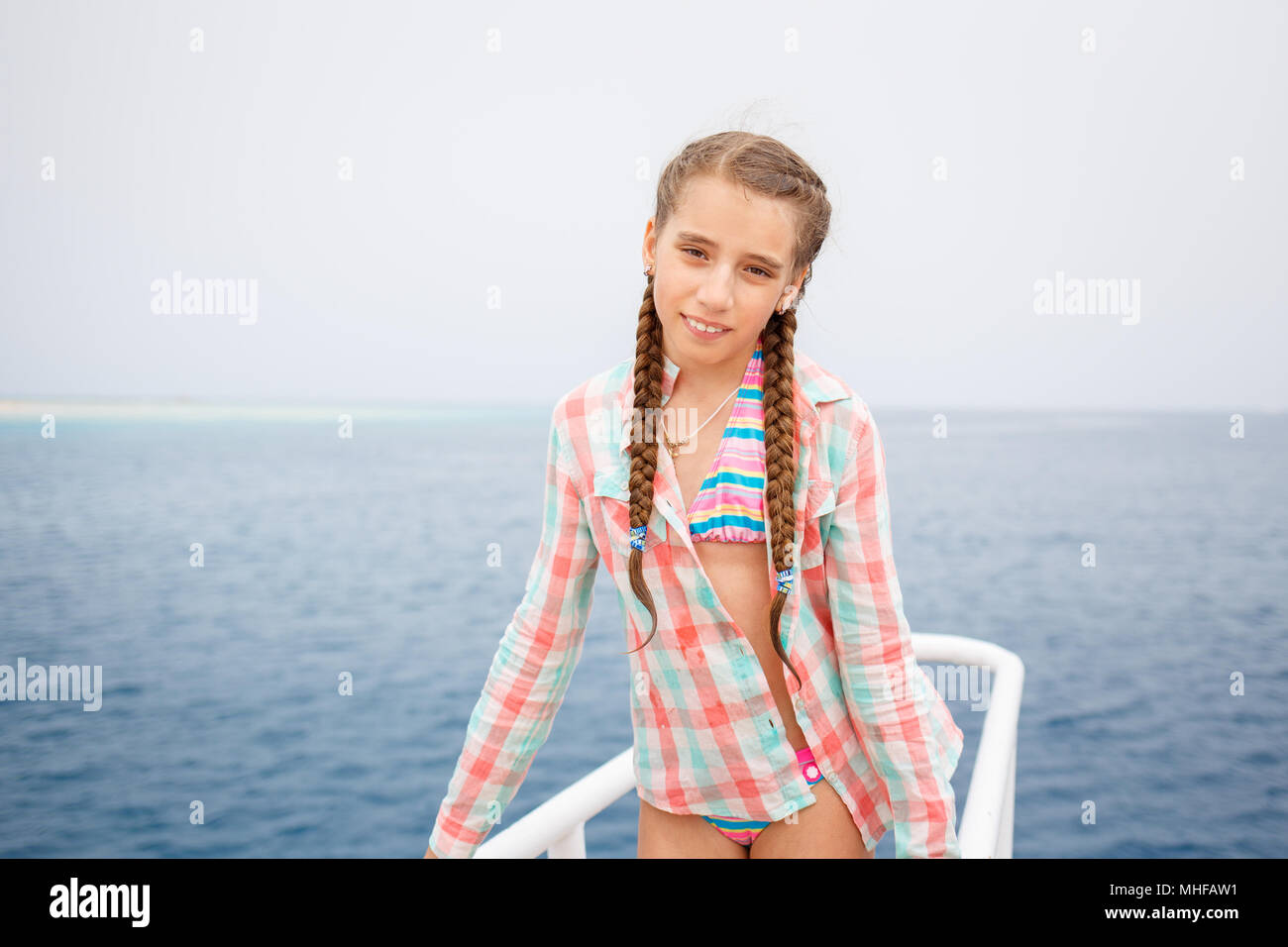 Young girl enjoying summer vacation on sea. Happy girl on yacht cruise. Vintage image with copy space Stock Photo