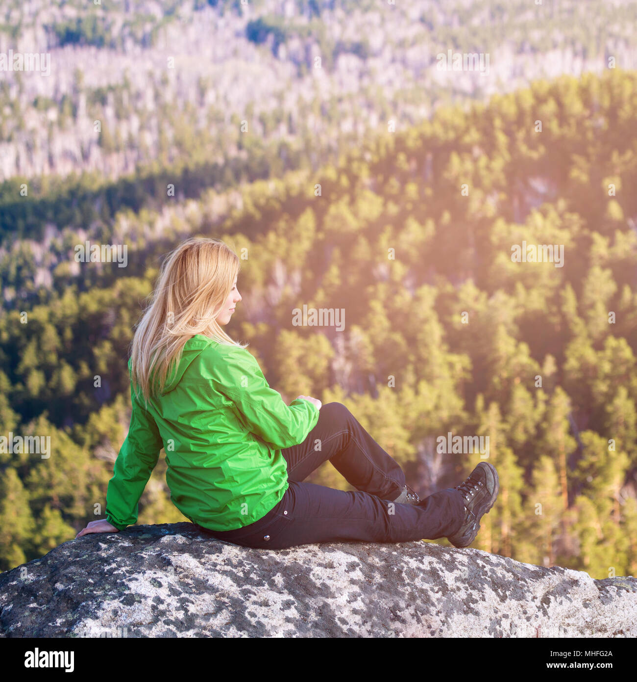 Young woman sitting on cliff's edge Stock Photo Alamy