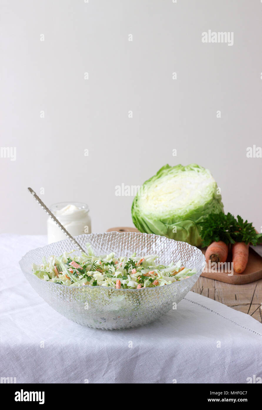 Fresh coleslaw salad in bowl and ingredients for salad. Rustic style