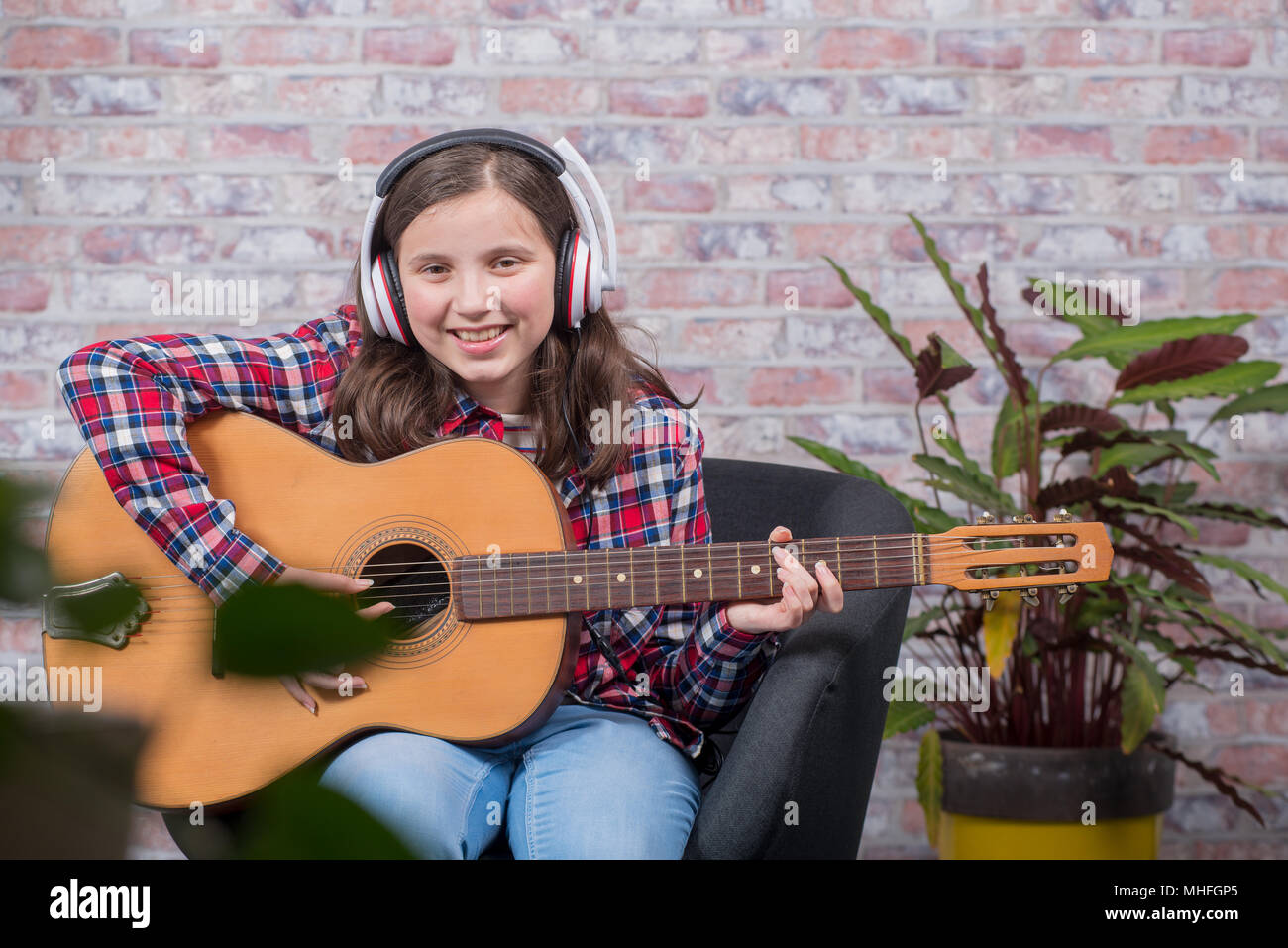 a smiling teenager girl playing an acoustic guitar Stock Photo - Alamy