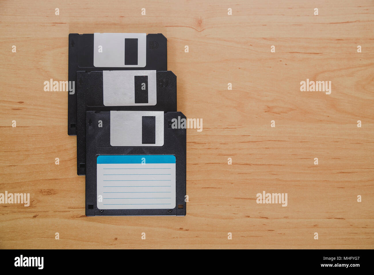 Three floppy disks on a wooden background Stock Photo