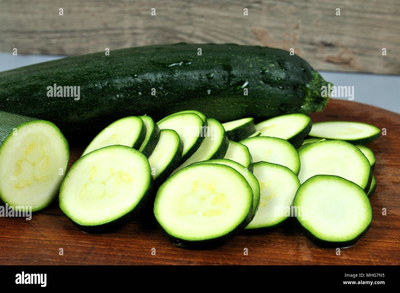 sliced zucchini on wooden cutting board Stock Photo