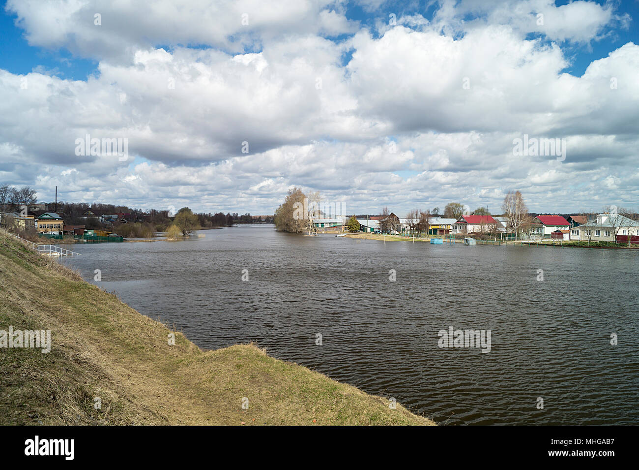 Spring flood in rural terrain on background blue sky with white cloud Stock Photo