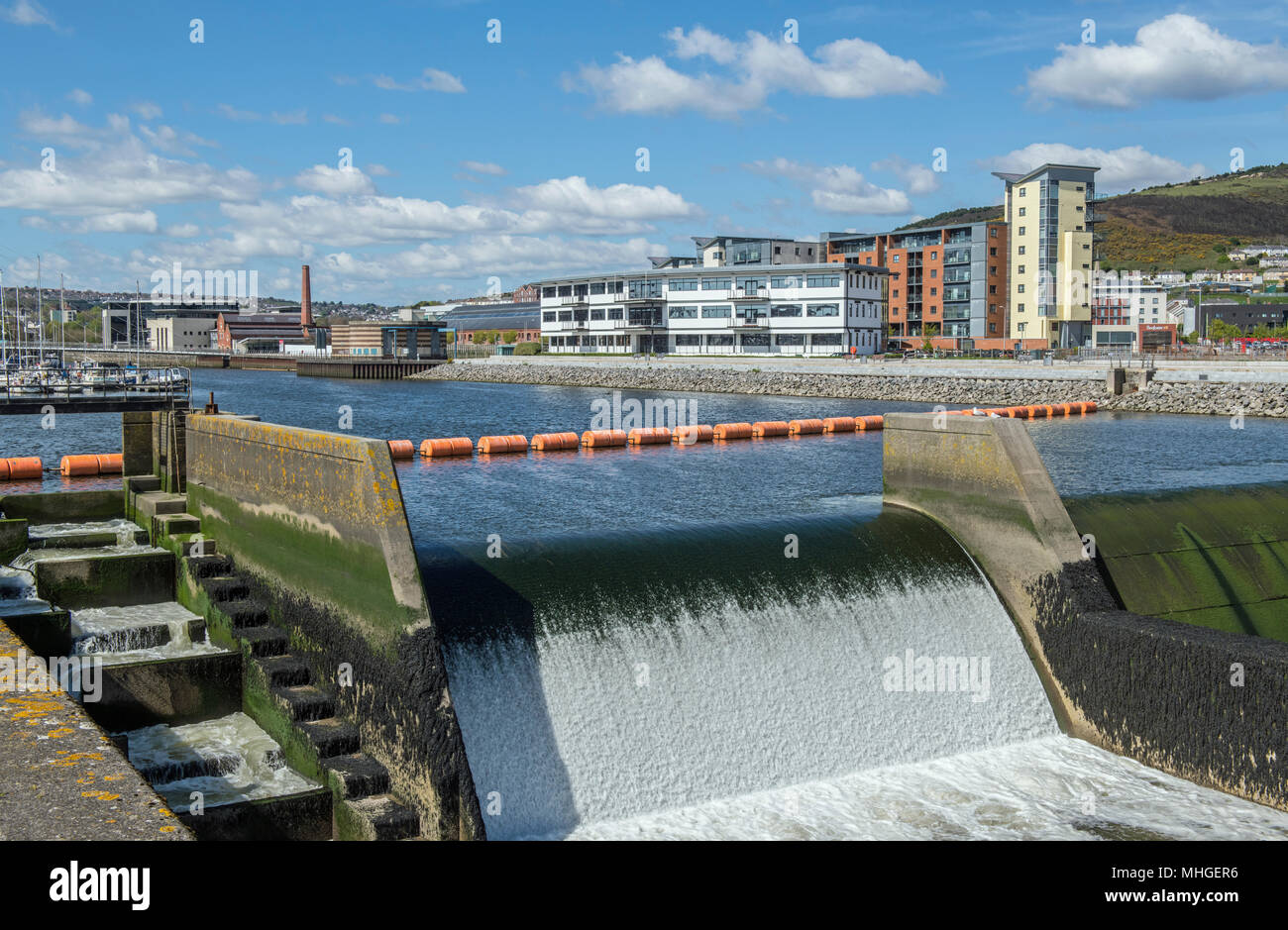 The River Tawe in Swansea as it gets nearer the sea, with a weir and lock gates in place Stock Photo
