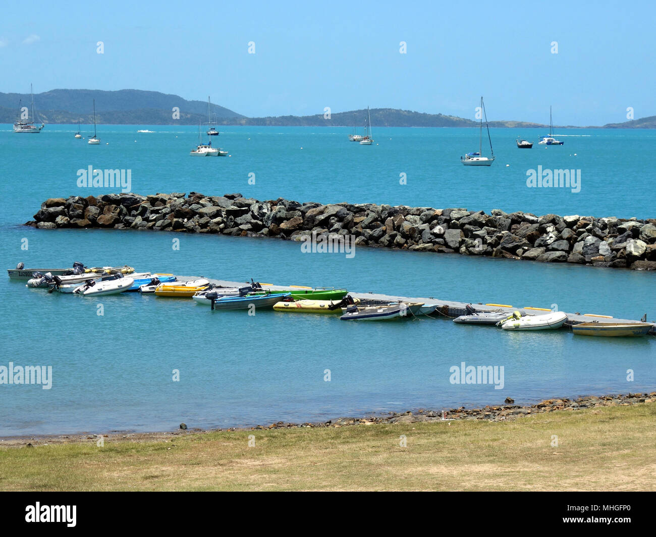Various types of tender boats tied to a floating pontoon inside a safe harbor at the Sailing Club in Stock Photo