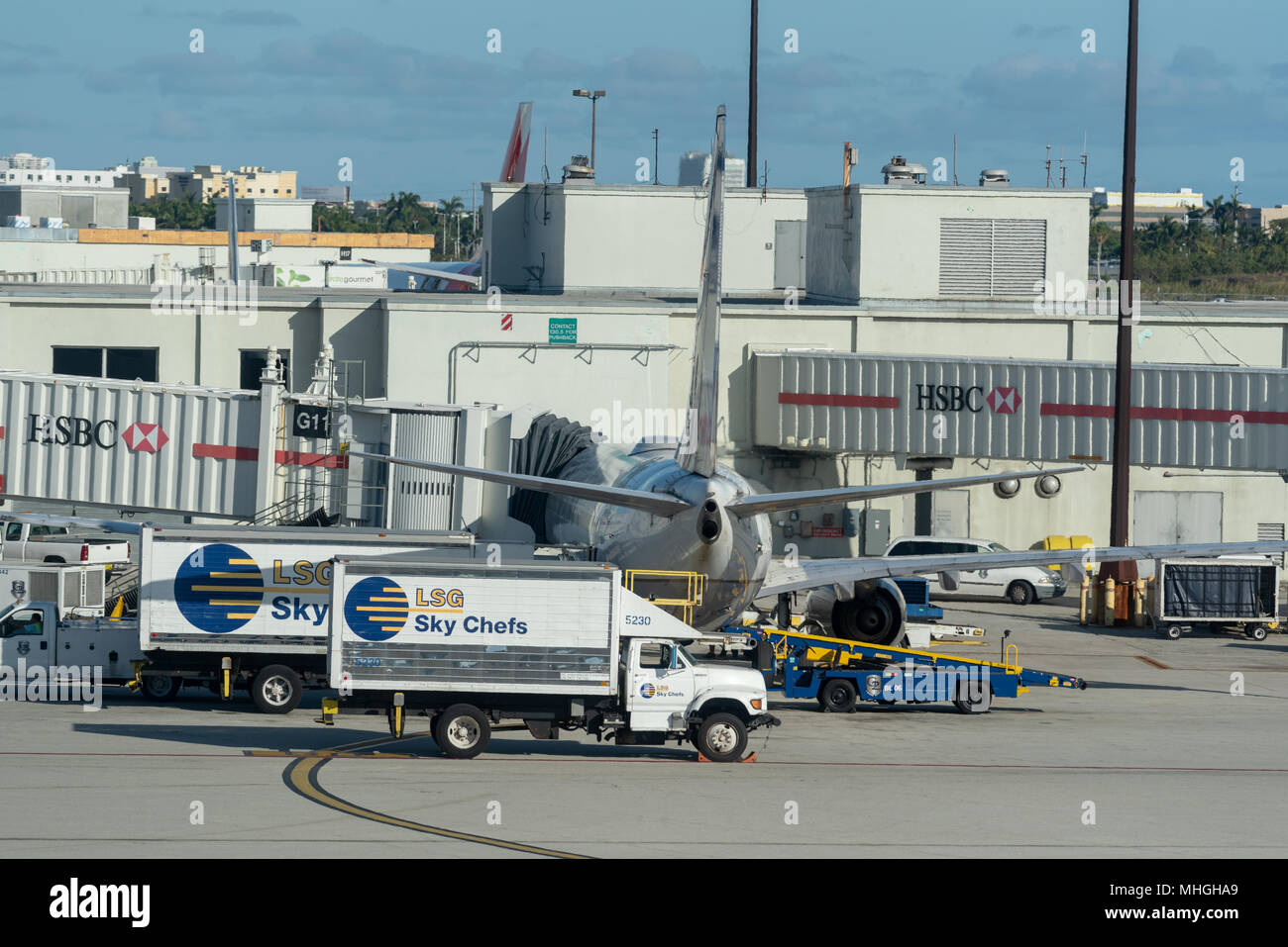 Catering trucks at a jet at a gate of Miami International Airport in Miami, Florida. Stock Photo