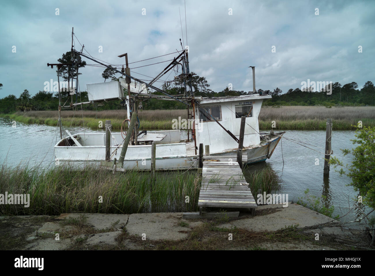Abandoned shrimp boat sits dockside on the Bon Secour River in deep south Alabama. Stock Photo