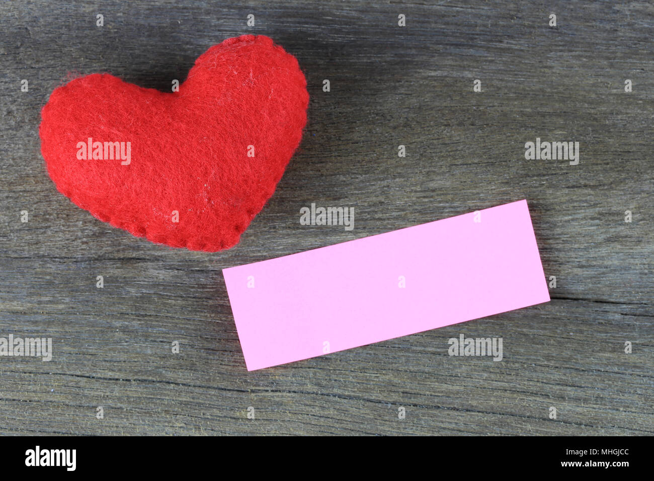 Red heart and blank paper note placed on a wooden floor and have copy ...