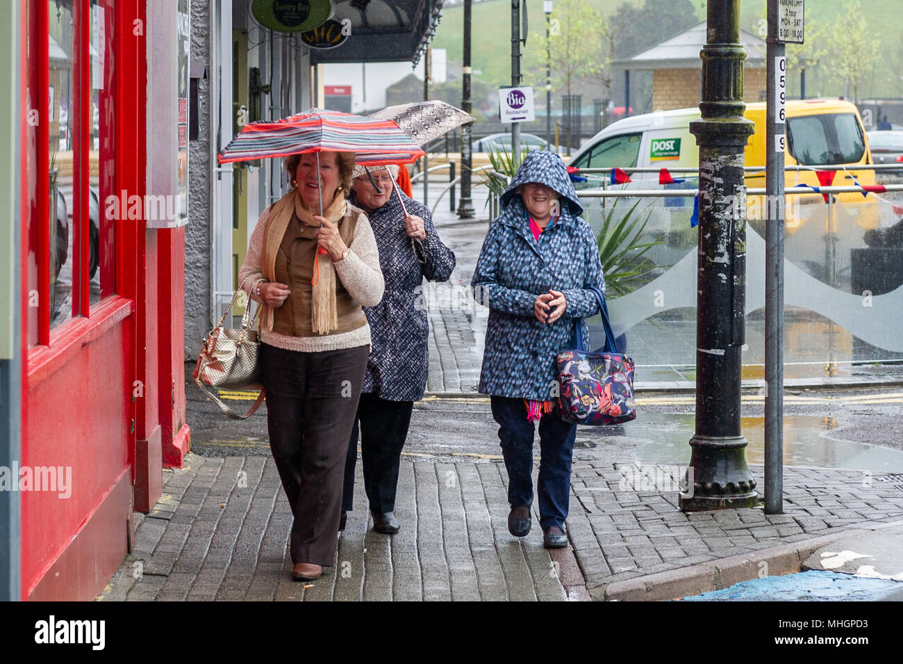 Bantry, Ireland. 1st May, 2018. A group of ladies seem to be happy as they struggle against the persistent rain and wind in Bantry, West Cork, Ireland. The rain will continue into the afternoon but drier weather will develop by evening. Credit: Andy Gibson/Alamy Live News. Stock Photo