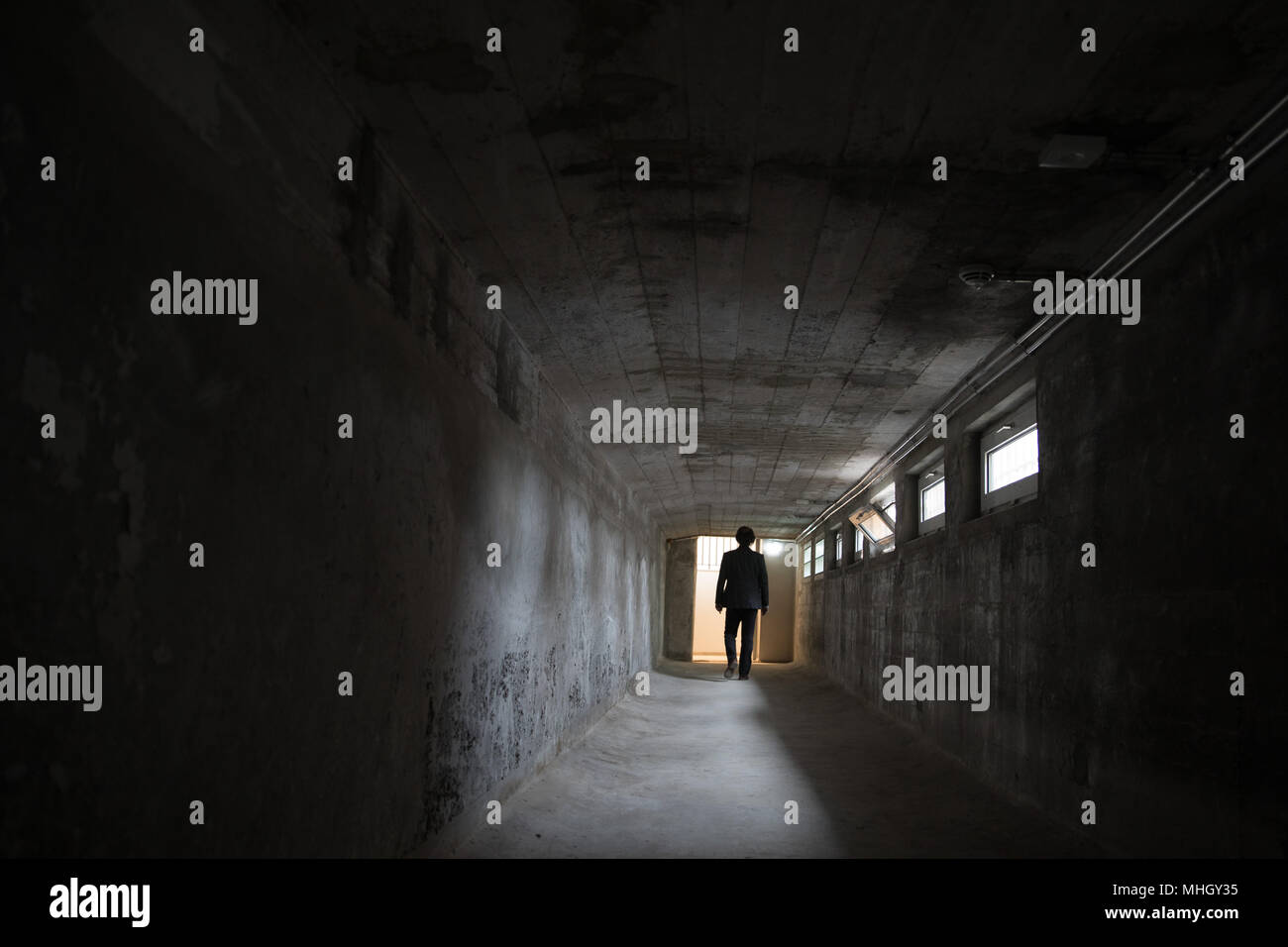 01 May 2018, Germany, Hamburg: A man walking through a historical walkway in the 'Historical Town House'. Starting on 02 May a 'Historical Town House' will conmemorate for the first time the former HQs of the Nazi's Gestapo in Hamburg's Stadthoefe. The walkway used to lead from the former detention cells located in the basement to the Gestapo's interrogation rooms and used to be called 'alley of sighs'. Photo: Christian Charisius/dpa Stock Photo