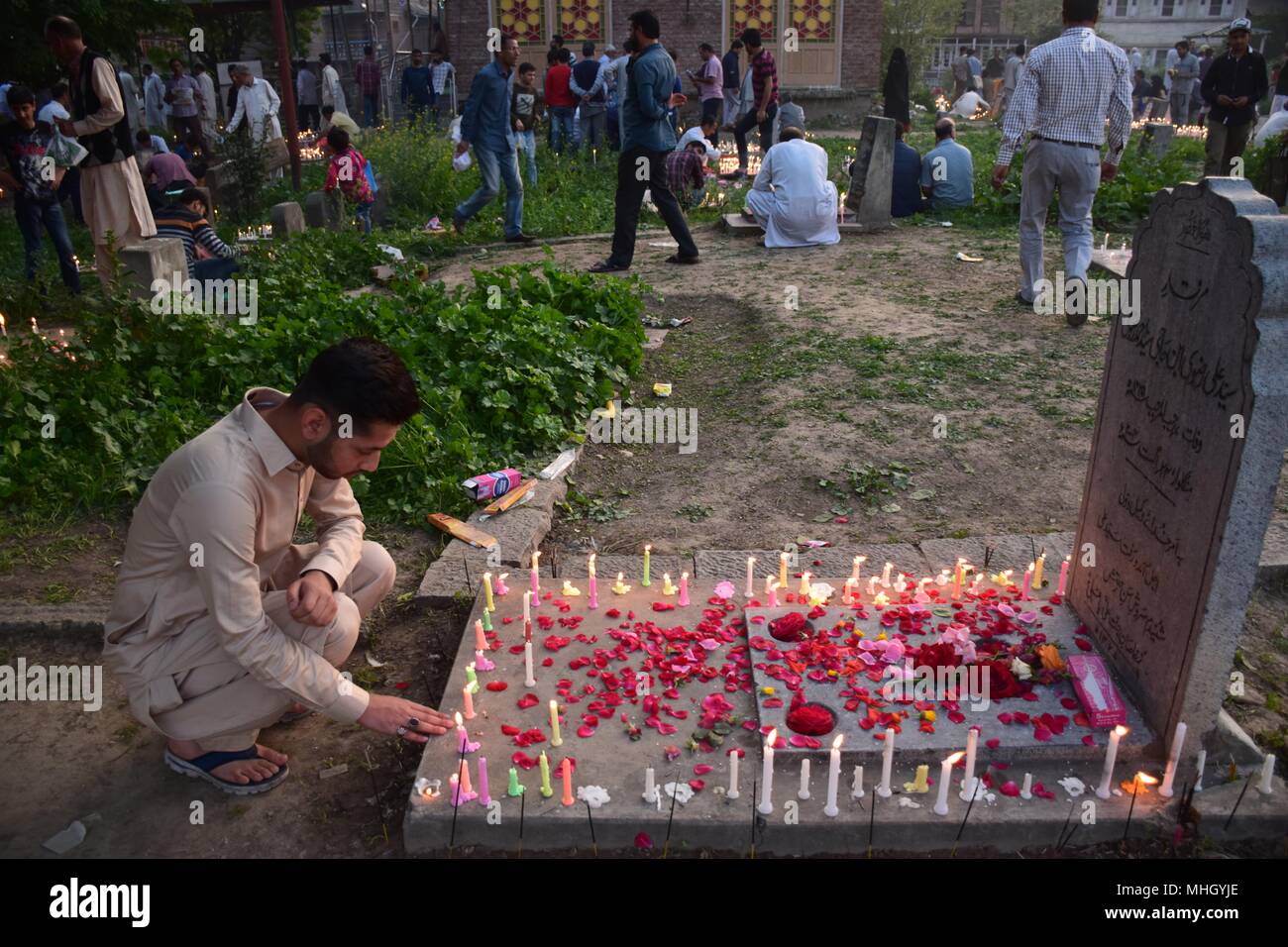 A Kashmiri Shia Muslim light candles on graves on the occasion of Shab-e-Baraat. Every year, Shab-e-Barat is observed on the night between 14th and 15th of Sha'aban, which is the eighth month of the Islamic calendar. According to Islam, Shab-e-Barat means the night of forgiveness. It is considered to be the night when Allah forgives sinners. Shab-e-Barat is also known as Bara'a Night and Mid-Sha'ban. In The Arab world, it's referred to as Laylat al-Bara'at. The festival falls in the run up to Ramadan and is considered the night when Allah forgives sinners. Stock Photo