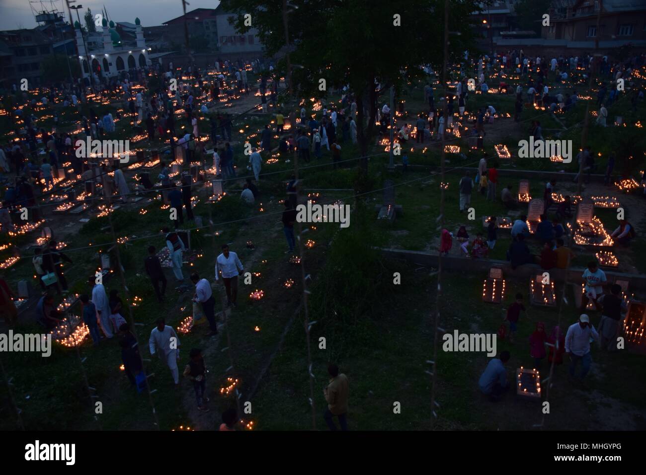 May 1, 2018 - Srinagar, Jammu & Kashmir, India - Kashmiri Shia Muslims light candles on graves on the occasion of Shab-e-Baraat.Every year, Shab-e-Barat is observed on the night between 14th and 15th of Sha'aban, which is the eighth month of the Islamic calendar. According to Islam, Shab-e-Barat means the night of forgiveness. It is considered to be the night when Allah forgives sinners.Shab-e-Barat is also known as Bara'a Night and Mid-Sha'ban. In The Arab world, it's referred to as Laylat al-Bara'at. The festival falls in the run up to Ramadan and is considered the night when Allah forgive Stock Photo
