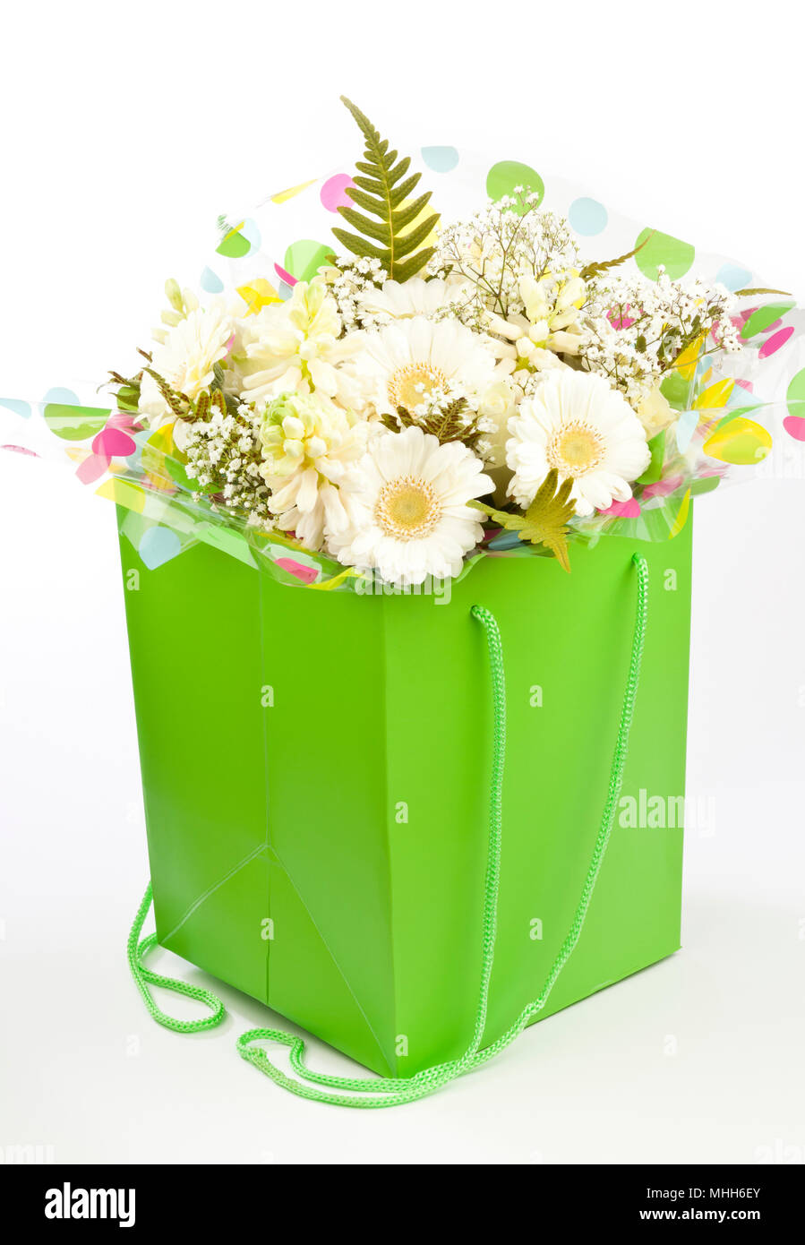 A lime green bag filled with cream coloured flowers Stock Photo