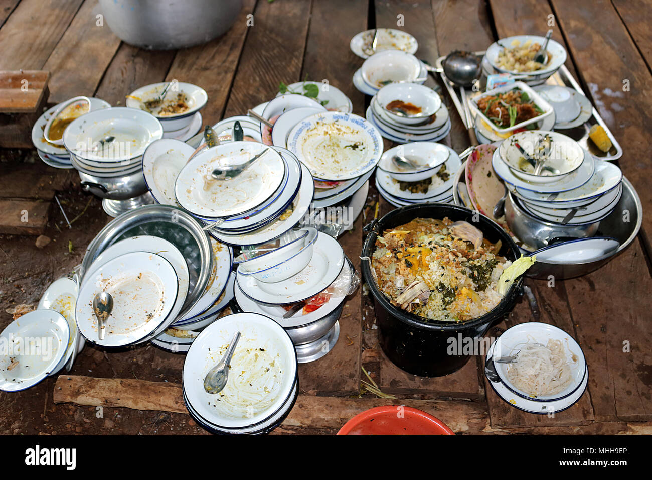 Plate, bowl, spoon. Have not washed. Are stack on wooden board. Food