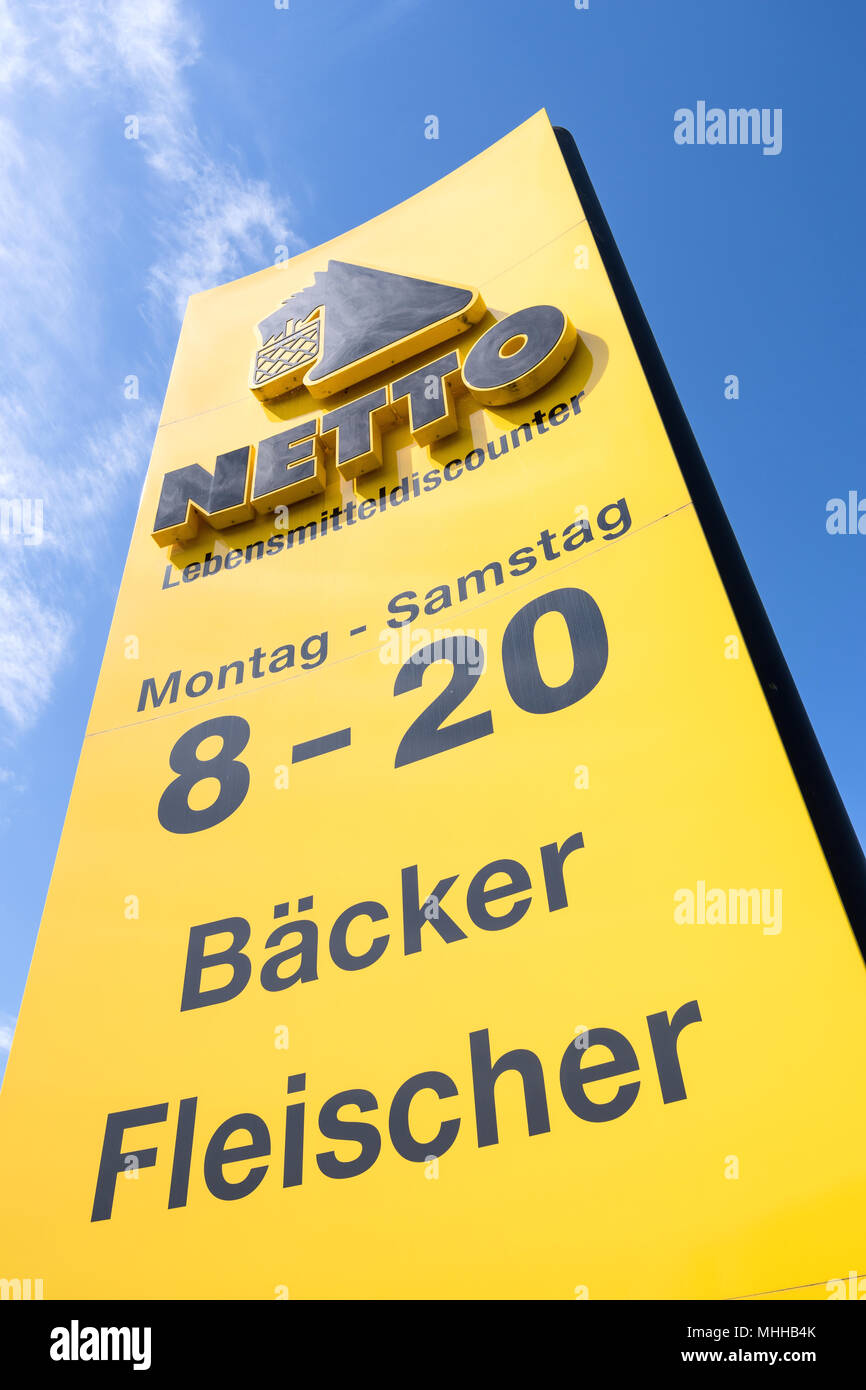 Netto Lebensmitteldiscounter sign against blue sky. Netto is a Danish discount supermarket operating in Denmark, Germany, Poland and Sweden. Stock Photo