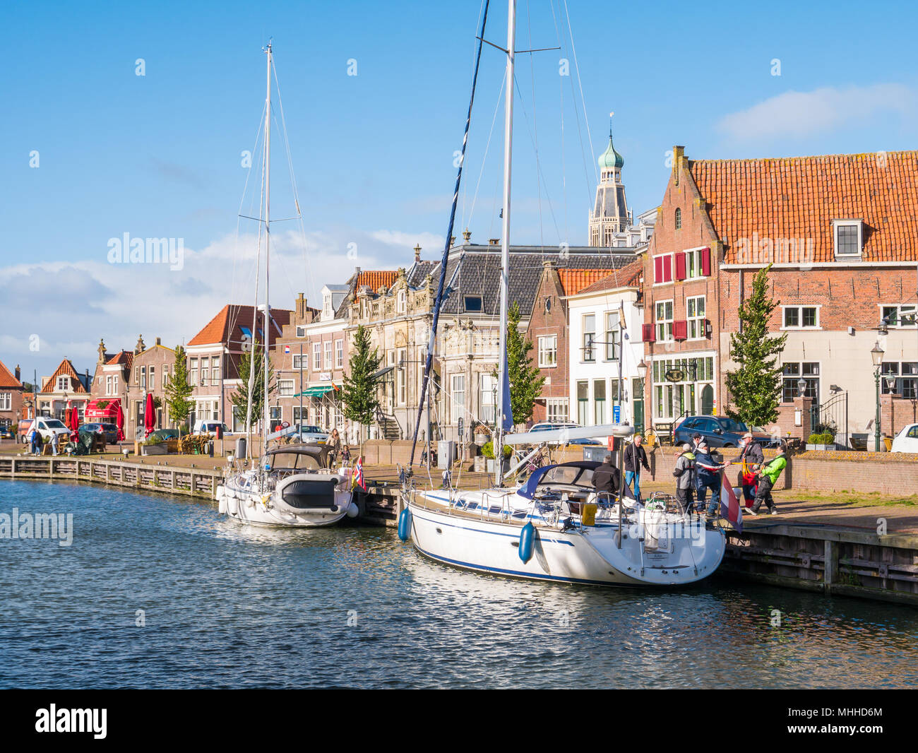 People and sailboats on canal in old town of Enkhuizen, North Holland, Netherlands Stock Photo